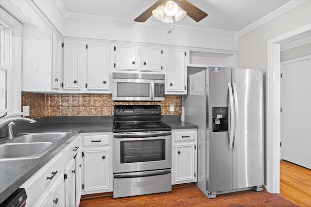 kitchen featuring white cabinets, sink, dark hardwood / wood-style floors, decorative backsplash, and stainless steel appliances