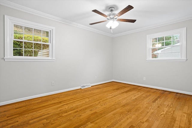 empty room featuring plenty of natural light, crown molding, and light hardwood / wood-style flooring