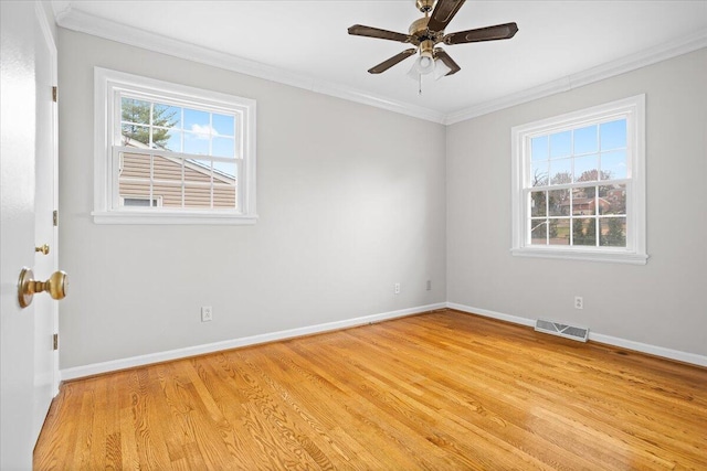 spare room with crown molding, plenty of natural light, and light wood-type flooring