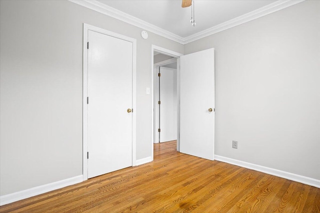 unfurnished bedroom featuring ceiling fan, crown molding, and light hardwood / wood-style flooring