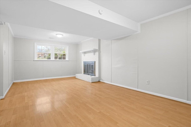 unfurnished living room featuring light wood-type flooring, a fireplace, and ornamental molding