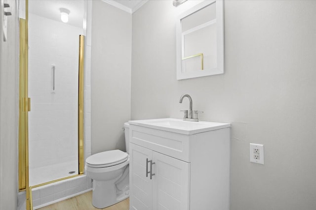 bathroom with ornamental molding, vanity, a shower with door, hardwood / wood-style floors, and toilet