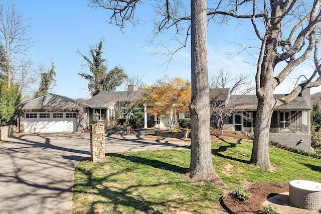 ranch-style home featuring a sunroom, a front yard, and a garage