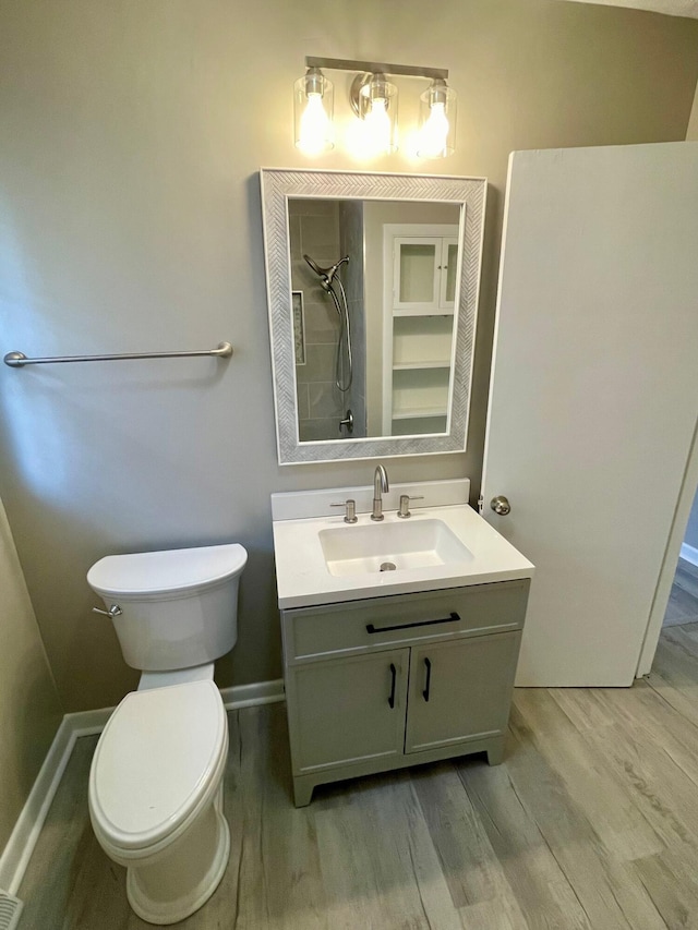 bathroom with a shower, vanity, wood-type flooring, and toilet