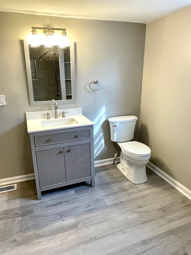 bathroom featuring wood-type flooring, vanity, and toilet