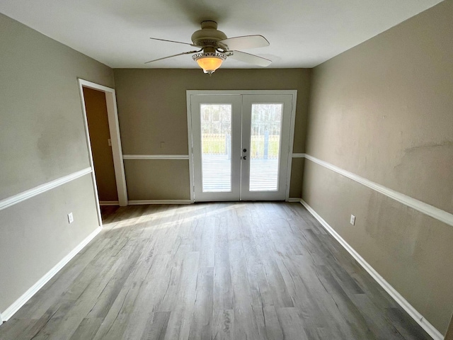 empty room with ceiling fan, french doors, and light hardwood / wood-style floors