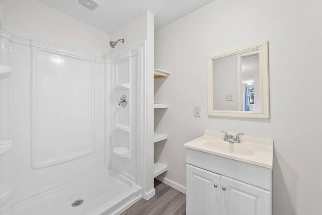 bathroom with a shower, hardwood / wood-style floors, and vanity