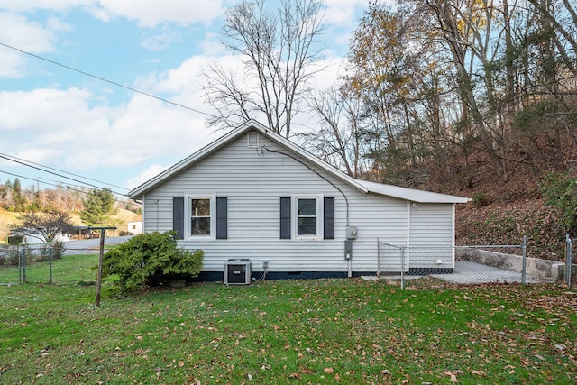 view of side of property with a lawn and cooling unit