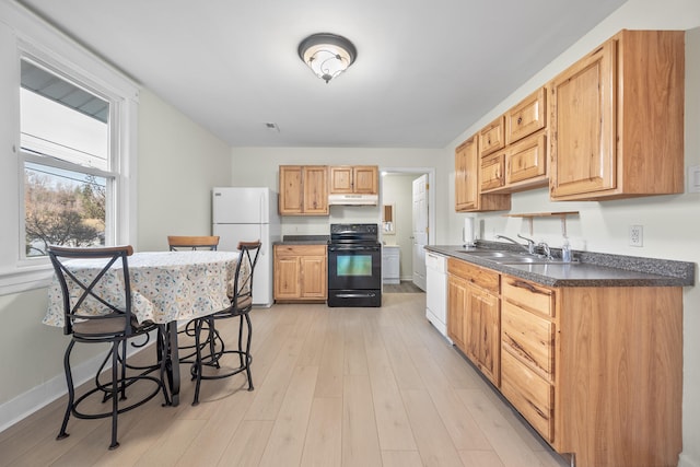 kitchen with light wood-type flooring, a kitchen bar, white appliances, and sink