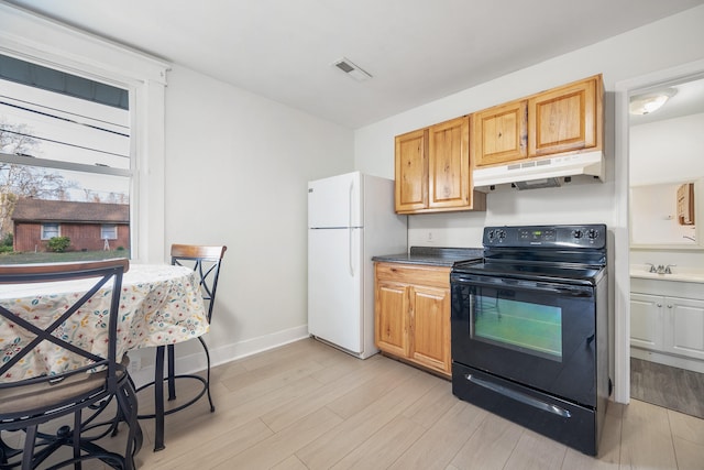 kitchen with light hardwood / wood-style flooring, white fridge, and black range with electric cooktop