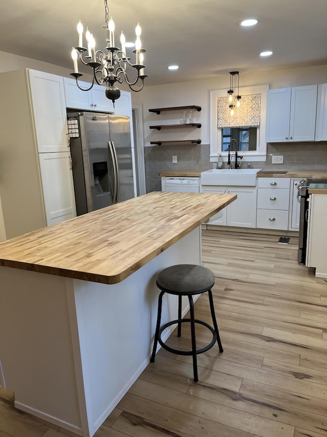 kitchen with stainless steel fridge, a center island, and white cabinets