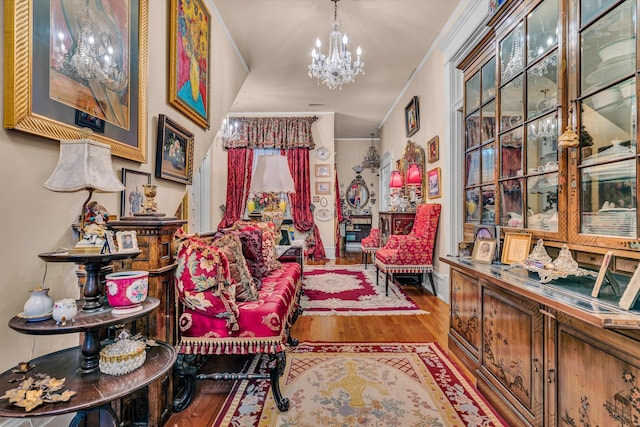 living area with a wealth of natural light, crown molding, hardwood / wood-style floors, and a notable chandelier