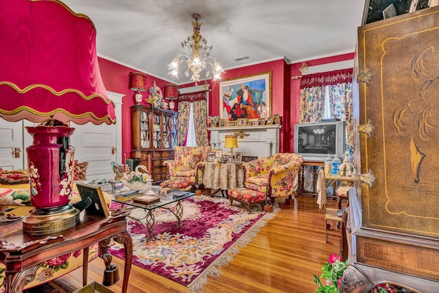 sitting room with a chandelier, hardwood / wood-style flooring, and crown molding