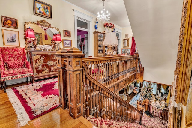 stairs featuring a notable chandelier and wood-type flooring