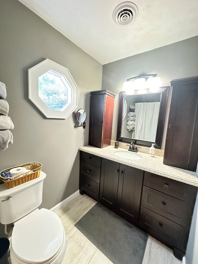 bathroom with hardwood / wood-style floors, vanity, and toilet