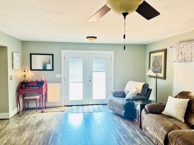 living area with french doors, baseboards, ceiling fan, and wood finished floors