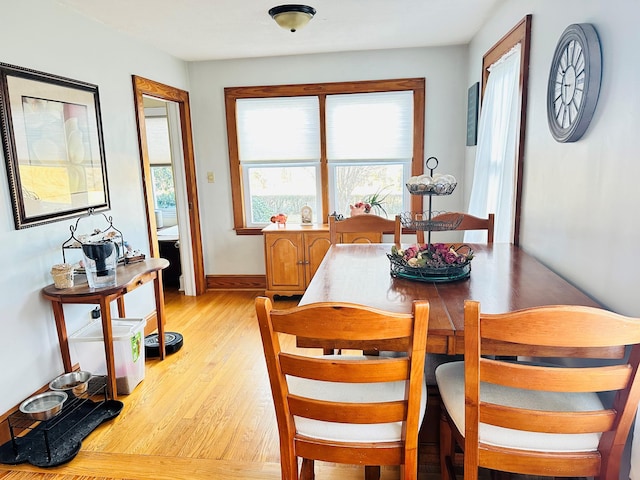 dining space with light wood-style flooring and baseboards