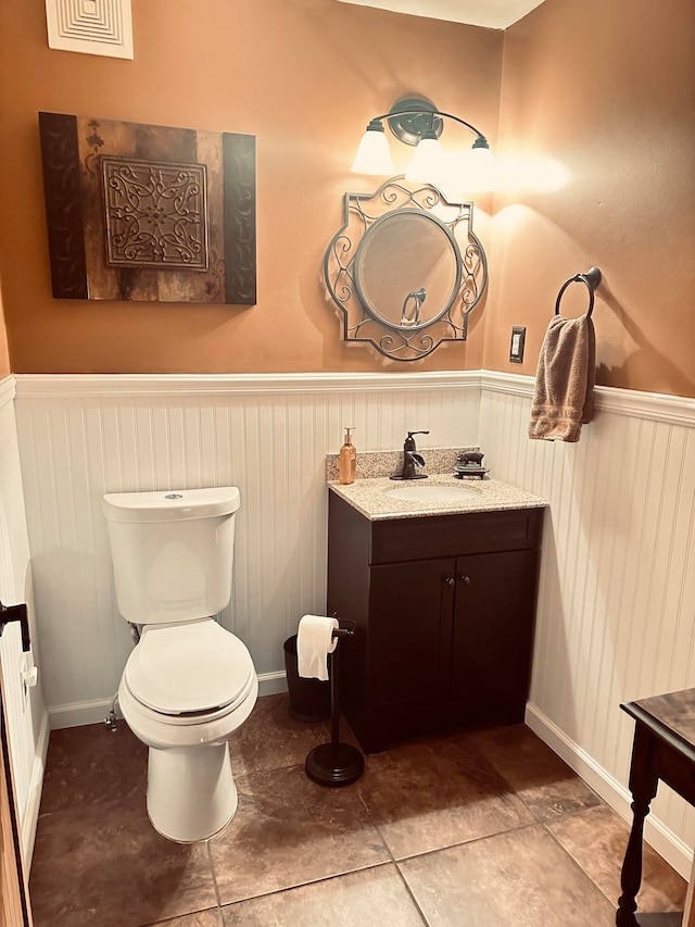 bathroom with tile patterned flooring, vanity, and toilet