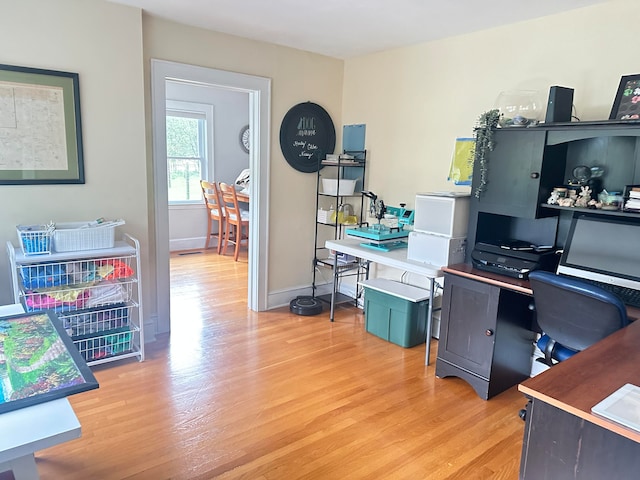 home office with baseboards and light wood-type flooring