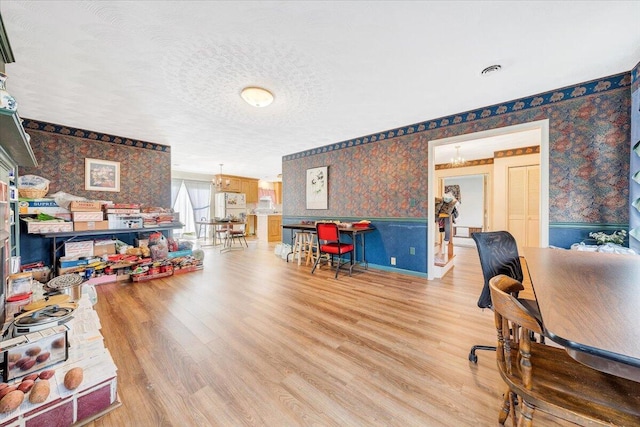 office area with an inviting chandelier, a textured ceiling, and light hardwood / wood-style flooring