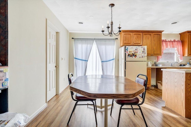 dining space featuring an inviting chandelier and light hardwood / wood-style floors