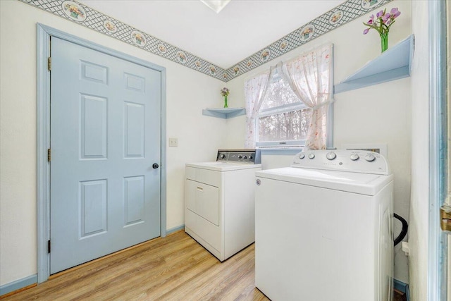 clothes washing area featuring light hardwood / wood-style floors and washing machine and dryer