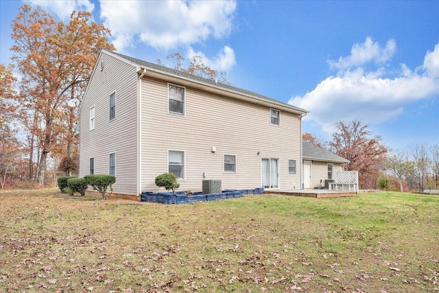 rear view of house with central AC unit, a yard, and a deck