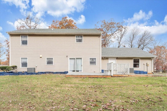 back of property featuring central AC, a deck, and a lawn