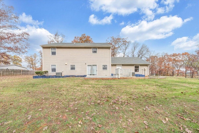 rear view of property featuring a yard and a deck