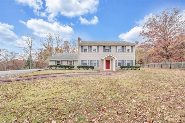 colonial home featuring a front lawn