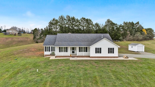 view of front of property featuring an outdoor structure, a front lawn, and a porch