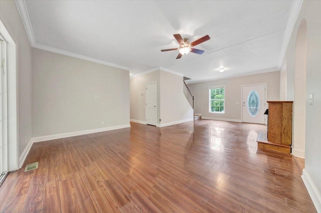 unfurnished living room featuring ceiling fan, wood-type flooring, and ornamental molding