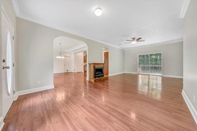 unfurnished living room with wood-type flooring and ornamental molding