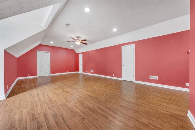 bonus room with wood-type flooring, a textured ceiling, ceiling fan, and lofted ceiling