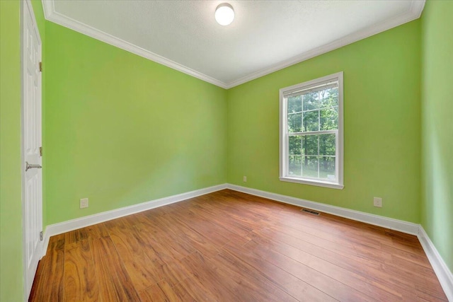 unfurnished room with hardwood / wood-style floors and crown molding