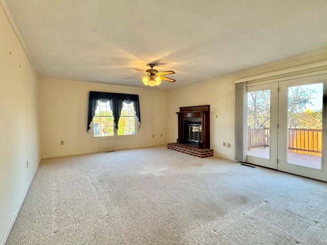 unfurnished living room with light carpet, a fireplace, ornamental molding, and ceiling fan