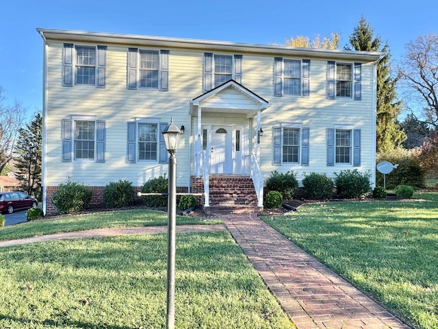 colonial inspired home featuring a front lawn