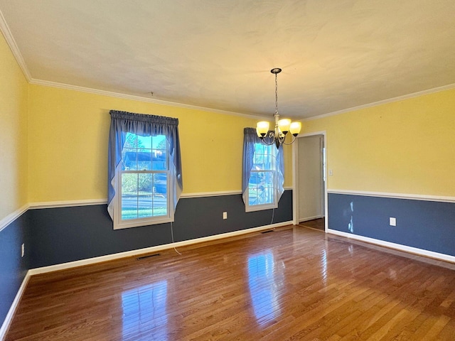 unfurnished dining area with hardwood / wood-style flooring, a healthy amount of sunlight, crown molding, and a chandelier