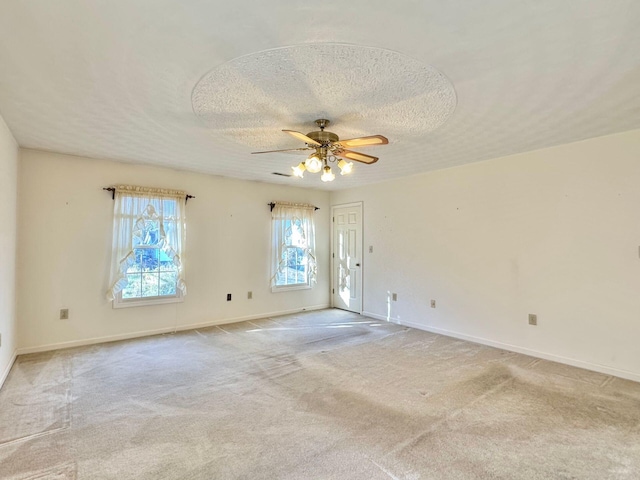 unfurnished room featuring ceiling fan, a textured ceiling, and light carpet