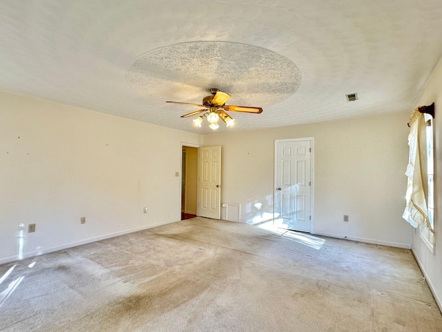 carpeted spare room with ceiling fan, plenty of natural light, and a textured ceiling