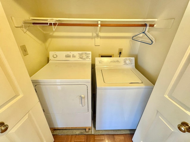 clothes washing area with hardwood / wood-style flooring and washing machine and dryer