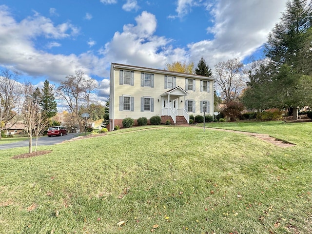 colonial-style house featuring a front lawn