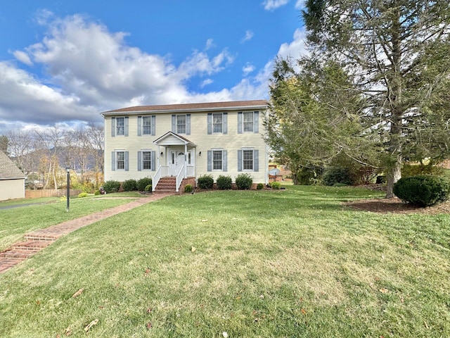 colonial-style house featuring a front yard