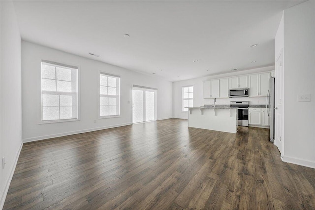 unfurnished living room with sink and dark hardwood / wood-style flooring