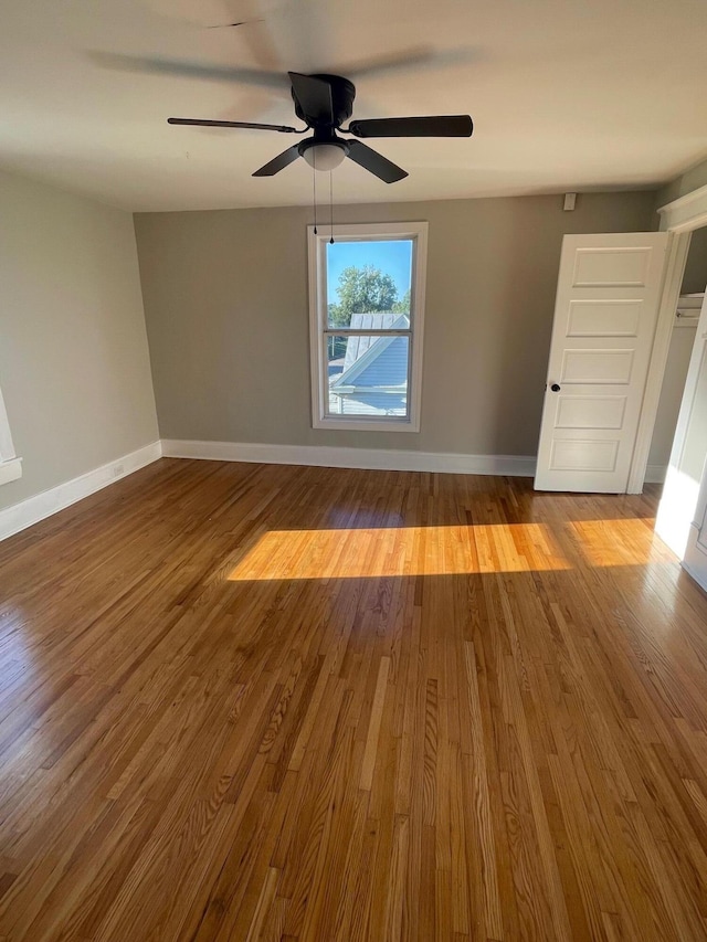 empty room with hardwood / wood-style flooring and ceiling fan