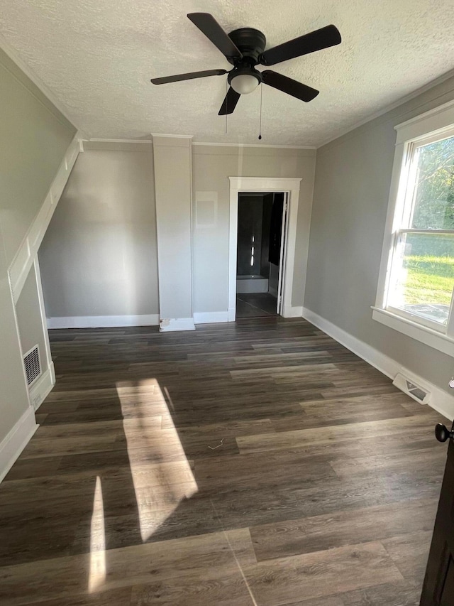 spare room featuring a textured ceiling, ceiling fan, and dark wood-type flooring