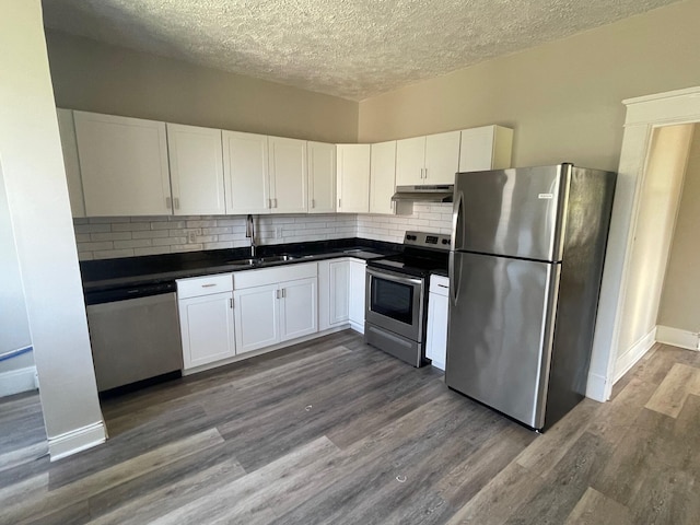 kitchen featuring white cabinets, stainless steel appliances, dark wood-type flooring, and sink