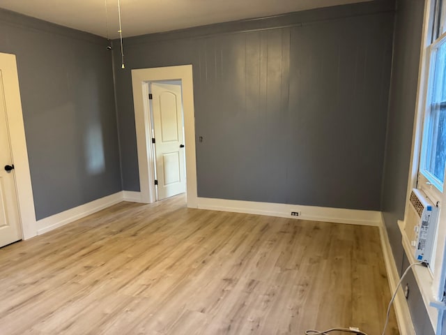 empty room with light hardwood / wood-style flooring and ornamental molding