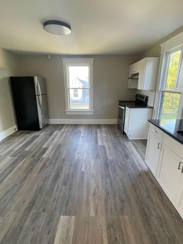 kitchen featuring appliances with stainless steel finishes, tasteful backsplash, white cabinetry, and dark wood-type flooring