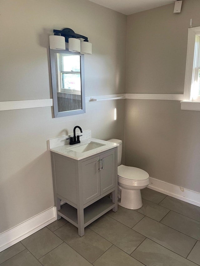 bathroom with tile patterned flooring, vanity, and toilet